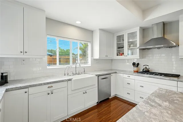 a kitchen with stainless steel appliances granite countertop a sink a stove and cabinets
