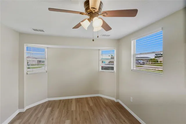 an empty room with a window and a fan