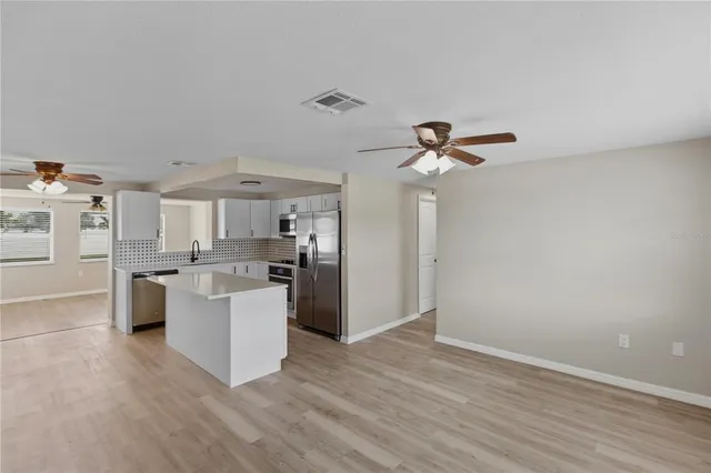 a kitchen with kitchen island a sink stainless steel appliances and cabinets