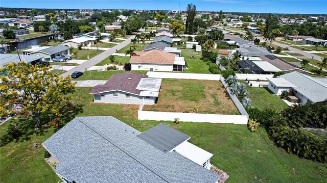 an aerial view of a house with a garden and lake view