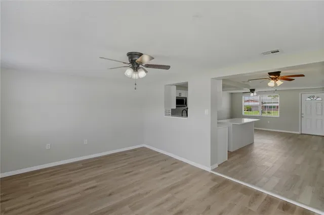 a view of an empty room with a window and a fan