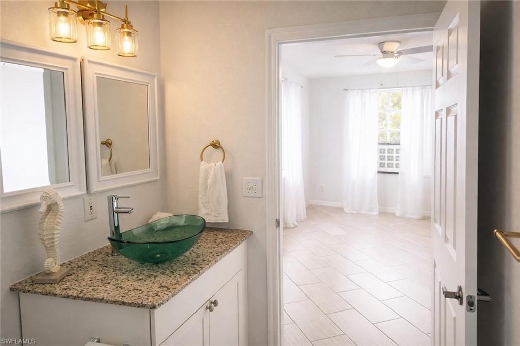 4635 St Croix Lane, Unit 1222 Naples, FL 34109 - Photo 11 of 20 a kitchen with granite countertop a sink and white cabinets