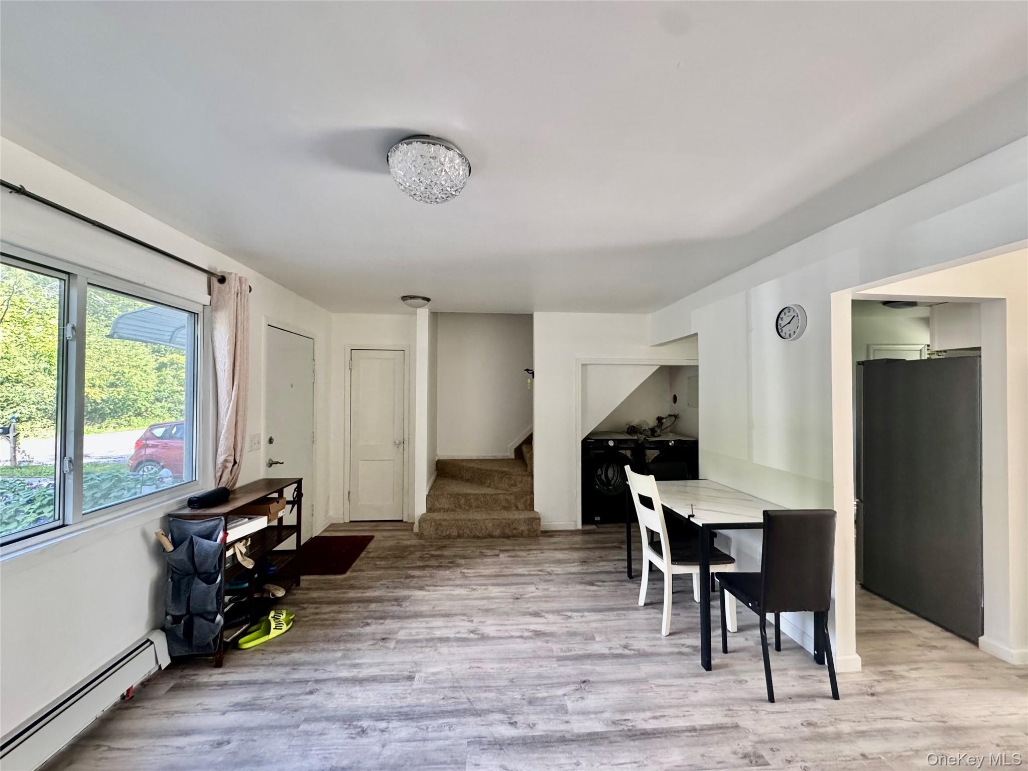 17 North Aspen Road Middletown, NY 10940 - Photo 4 of 12 Dining area featuring a baseboard heating unit, light wood finished floors, and stairway