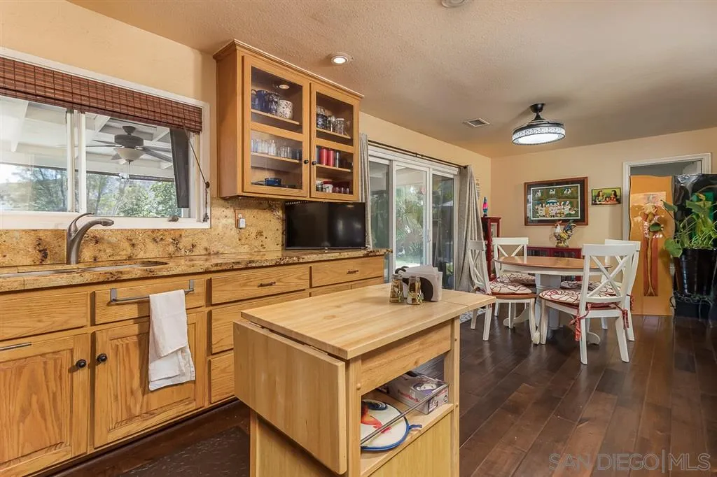 9215 Dalehurst Road Santee, CA 92071 - Photo 9 of 25 a open kitchen with stainless steel appliances granite countertop a stove and a wooden floors