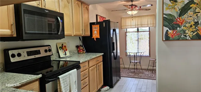 a kitchen with granite countertop a stove a sink and a microwave