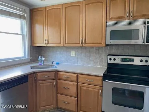 a kitchen with granite countertop white cabinets and stainless steel appliances
