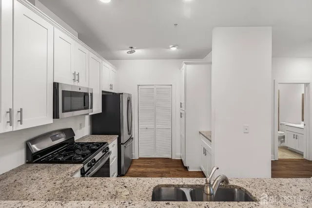 a kitchen with stainless steel appliances granite countertop a stove and a refrigerator