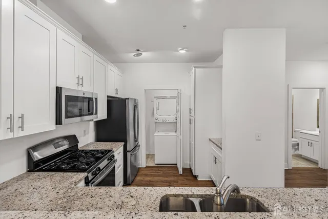 a kitchen with stainless steel appliances granite countertop a stove a sink and a refrigerator