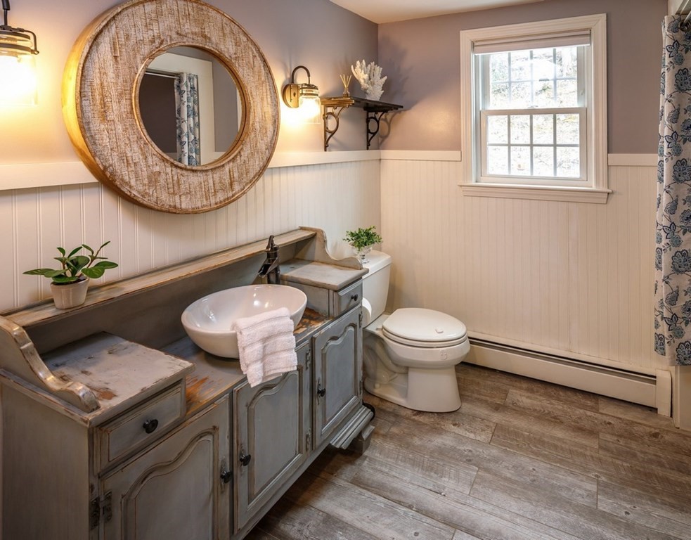 8 Olde Coach Road Westborough, MA 01581 - Photo 21 of 42 a bathroom with a granite countertop toilet a sink and a mirror