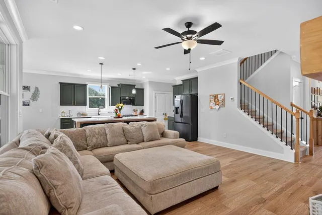 a living room with furniture and a view of kitchen