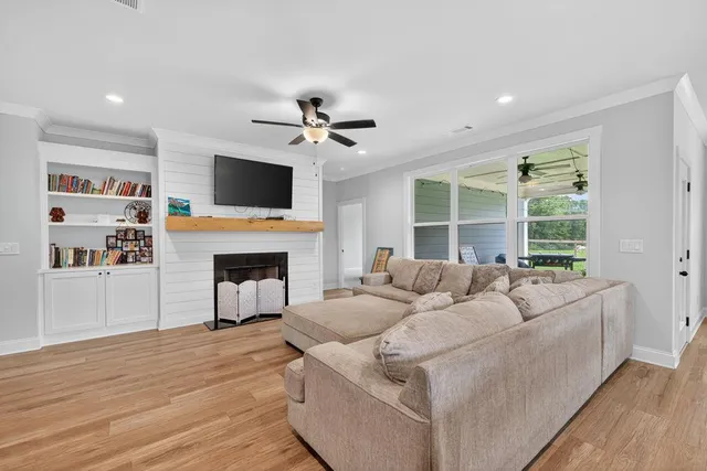 a living room with furniture a fireplace and a flat screen tv