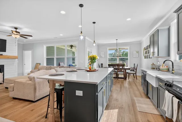 a view of kitchen with stainless steel appliances granite countertop a sink stove and living room view