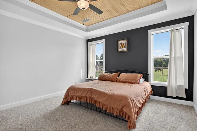 a bedroom with a bed lamp and a large window