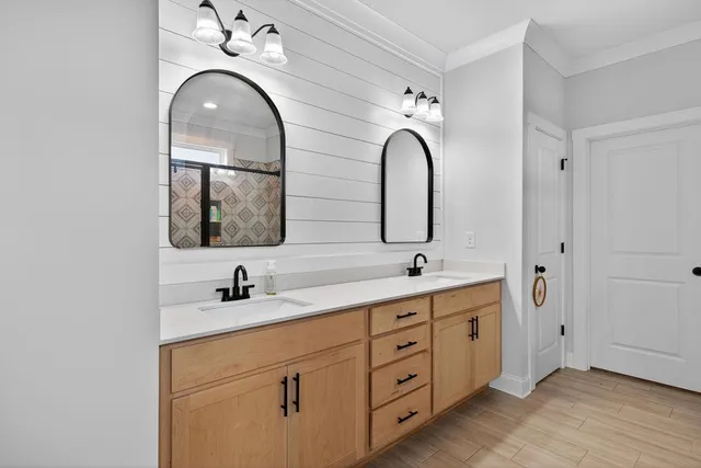 a bathroom with a double vanity sink and mirror with window
