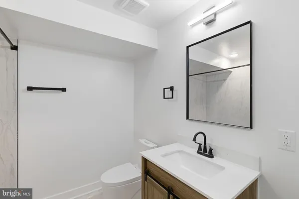 a bathroom with a sink toilet and mirror