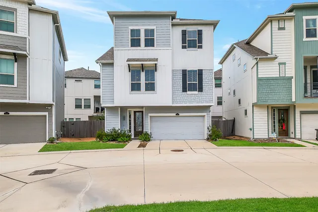 a front view of a house with a garden and garage