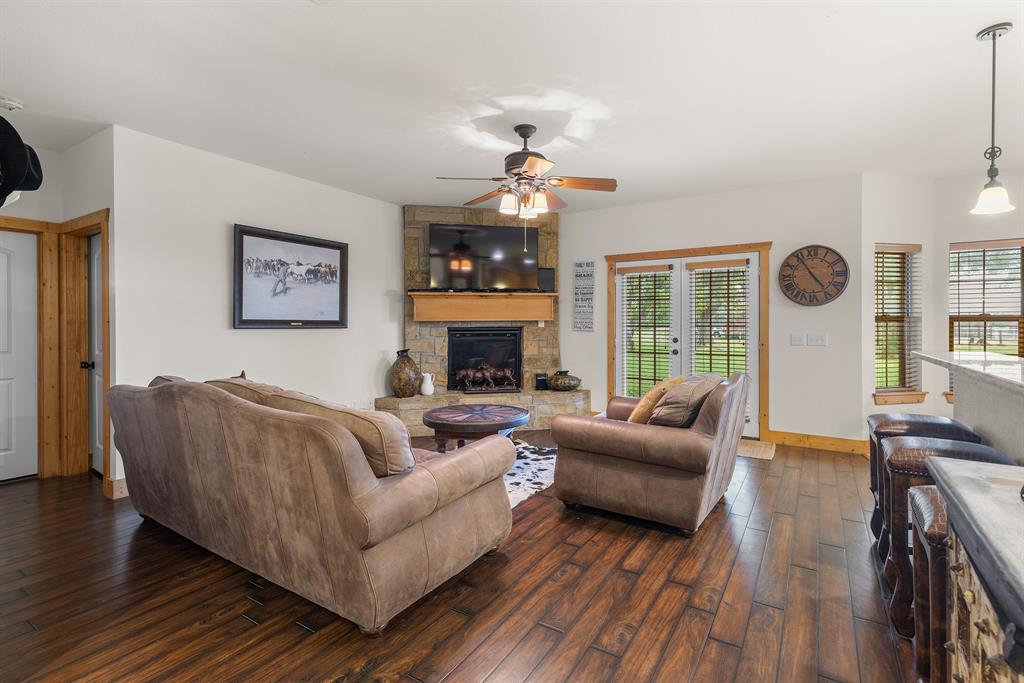 789 Stiles Road, Unit 789 Whitesboro, TX 76273 - Photo 16 of 34 Living area with dark wood-style flooring, a fireplace, and a ceiling fan