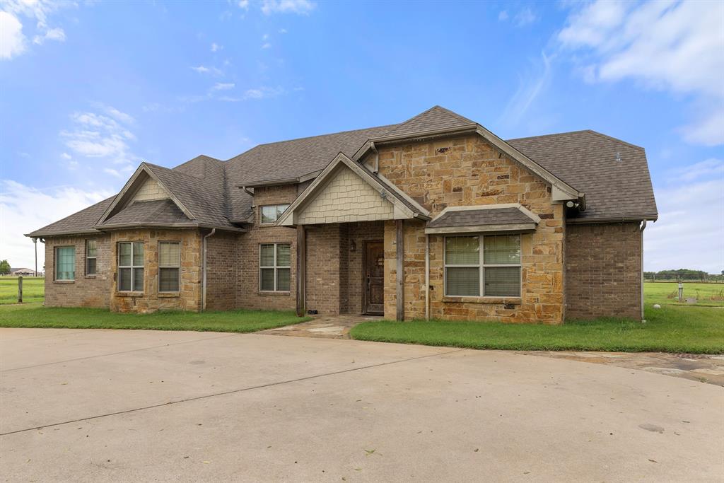 789 Stiles Road, Unit 789 Whitesboro, TX 76273 - Photo 4 of 34 View of front facade with a shingled roof, a front lawn, and stone siding