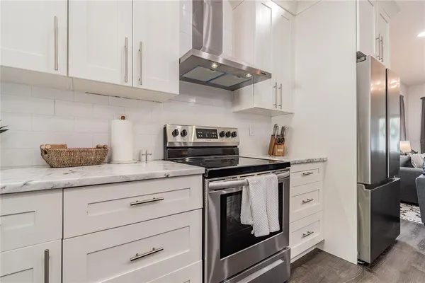 a kitchen with stainless steel appliances a sink a stove a refrigerator and cabinets