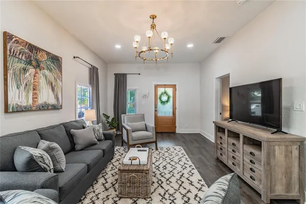 a living room with furniture kitchen view and a flat screen tv
