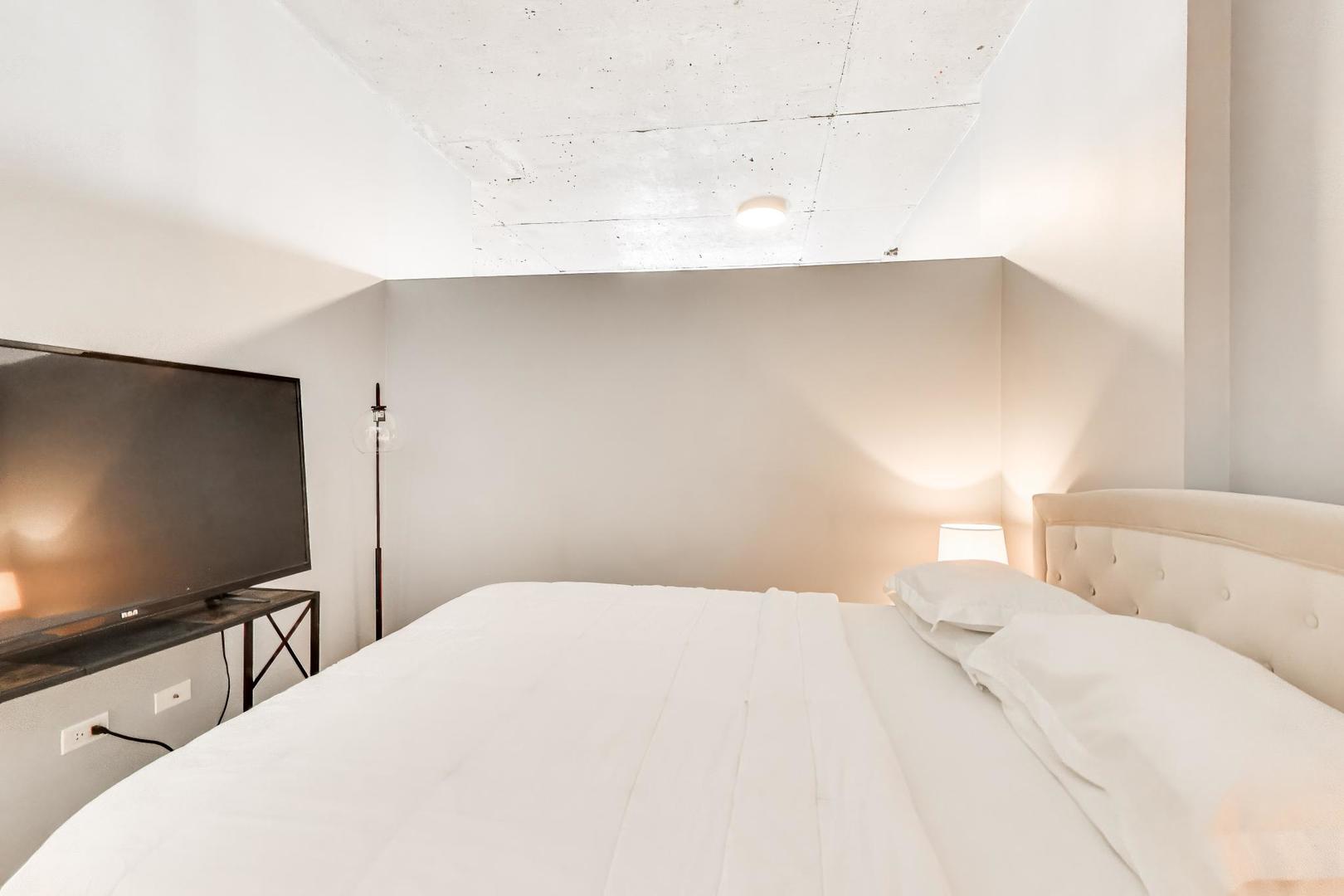 235 West Van Buren Street, Unit 2017 Chicago, IL 60607 - Photo 11 of 19 a bedroom with a bed and a flat screen tv