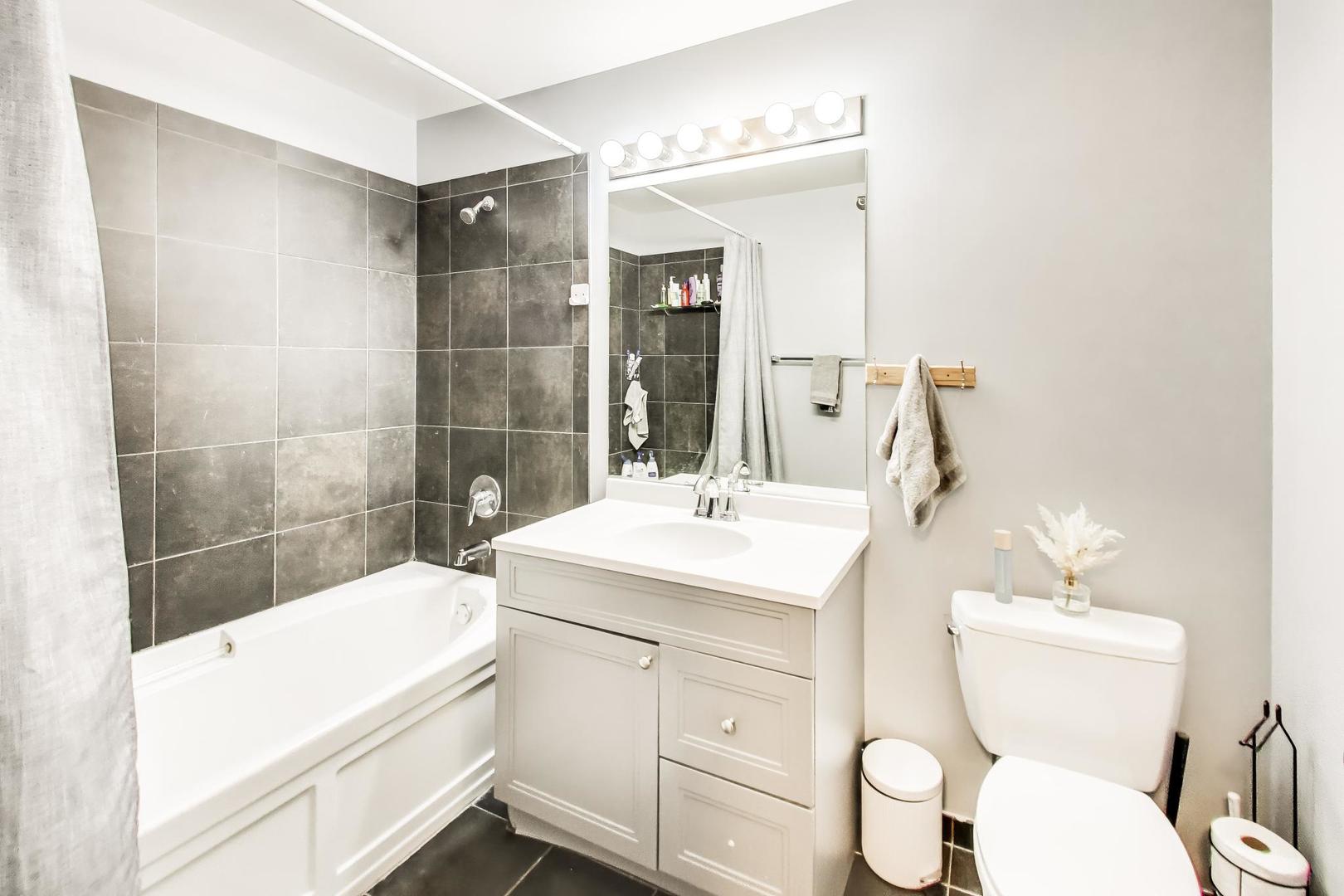 235 West Van Buren Street, Unit 2017 Chicago, IL 60607 - Photo 13 of 19 a bathroom with a sink toilet vanity and tub