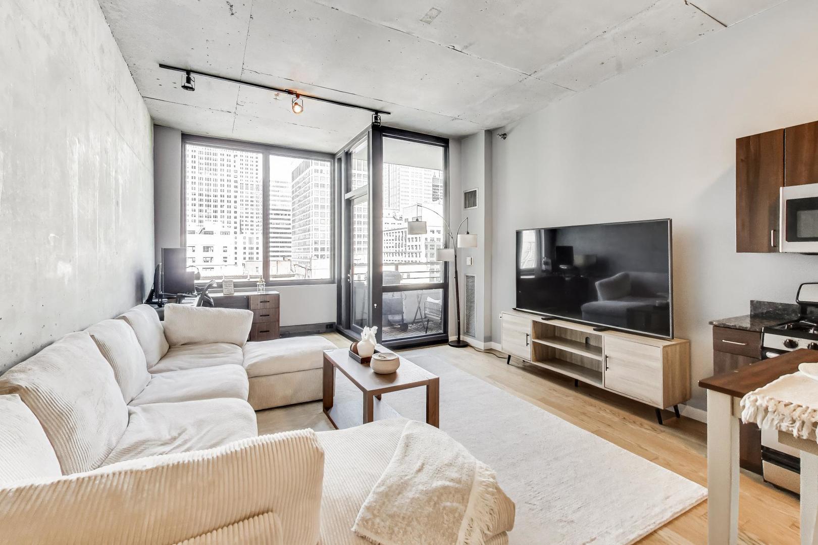 235 West Van Buren Street, Unit 2017 Chicago, IL 60607 - Photo 5 of 19 a living room with furniture and a flat screen tv