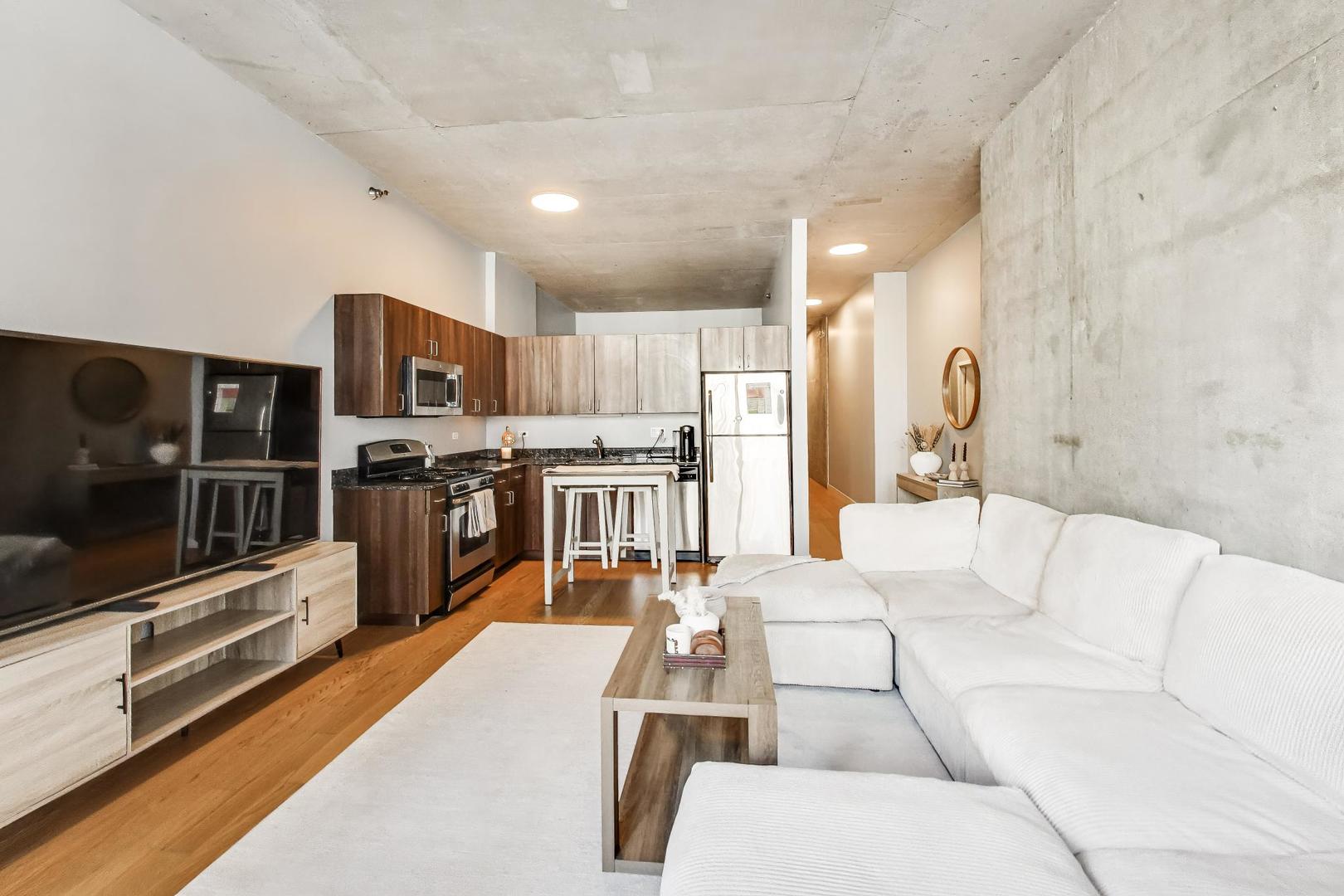 235 West Van Buren Street, Unit 2017 Chicago, IL 60607 - Photo 7 of 19 a living room with stainless steel appliances furniture a rug and a kitchen view
