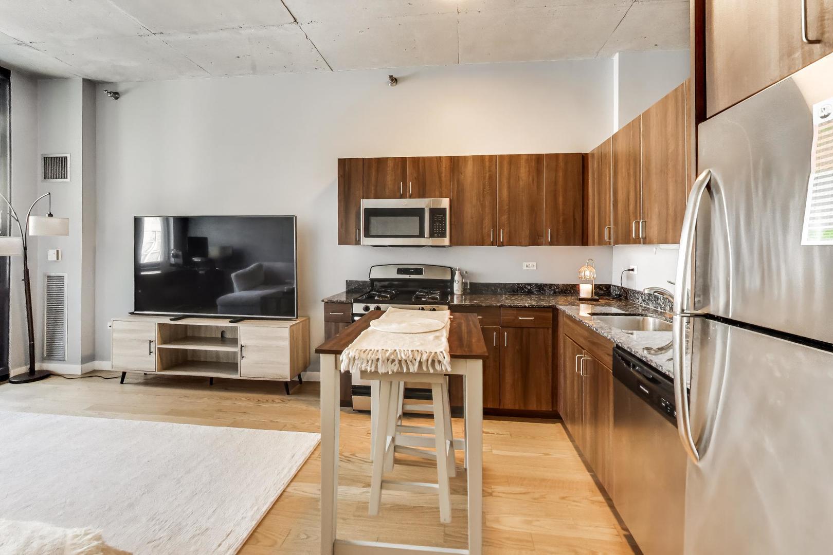 235 West Van Buren Street, Unit 2017 Chicago, IL 60607 - Photo 9 of 19 a kitchen with stainless steel appliances kitchen island granite countertop a refrigerator and a stove top oven