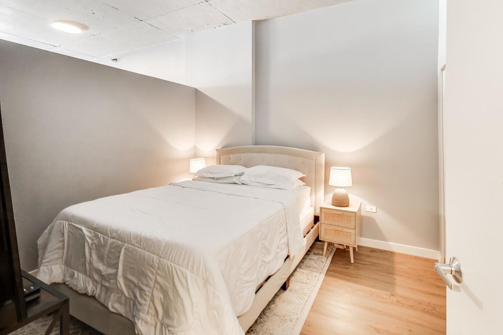 235 West Van Buren Street, Unit 2017 Chicago, IL 60607 - Photo 10 of 19 a bedroom with a bed and a lamp