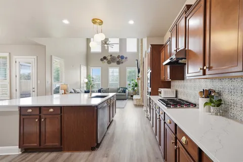 a kitchen with stainless steel appliances a sink stove and cabinets