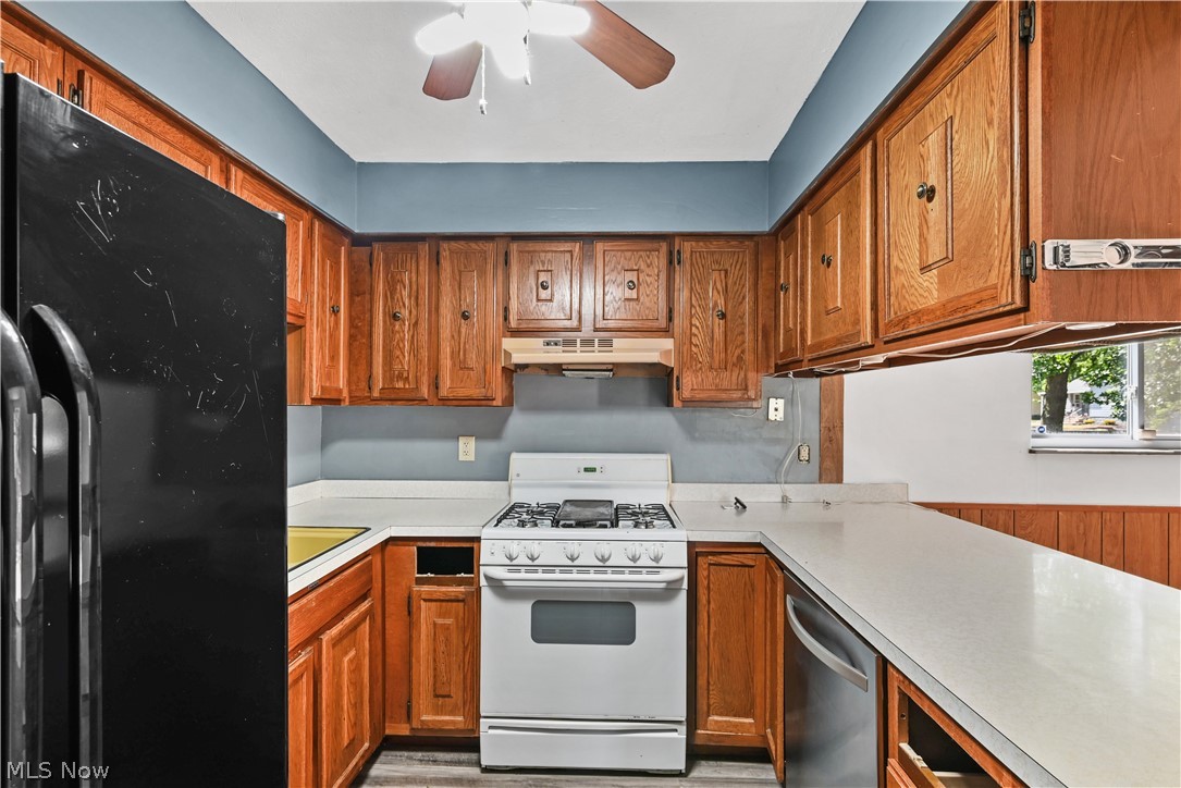 1286 Deforest Road Southeast Warren, OH 44484 - Photo 5 of 27 Kitchen featuring wood cabinetry, white countertops, built-in gas range, stainless steel dishwasher, and a ceiling fan