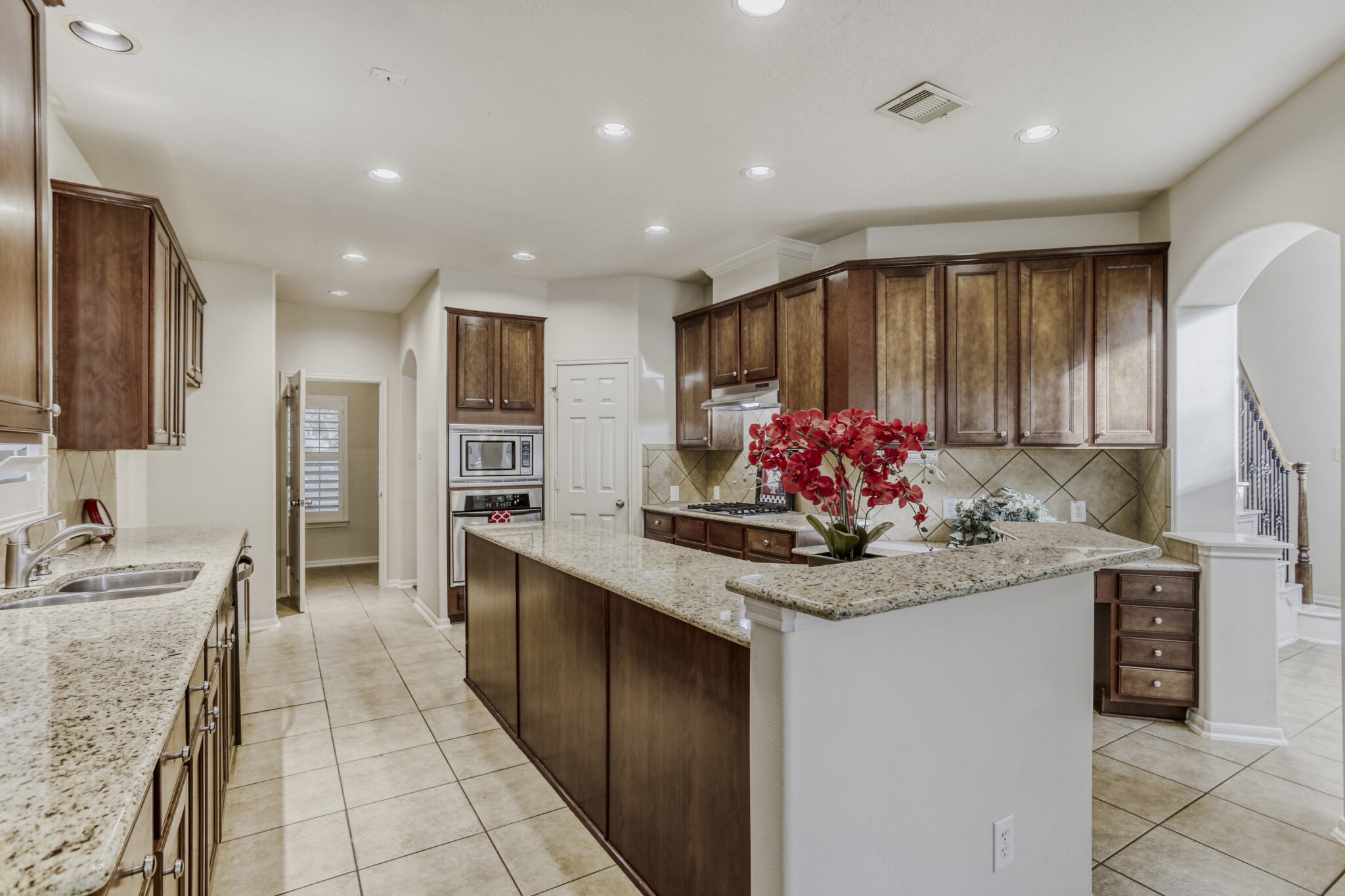 19303 Valiant Woods Drive Spring, TX 77379 - Photo 13 of 27 This spacious kitchen boasts elegant granite countertops, abundant cabinetry, and modern appliances, creating a perfect blend of functionality and style for culinary enthusiasts.
