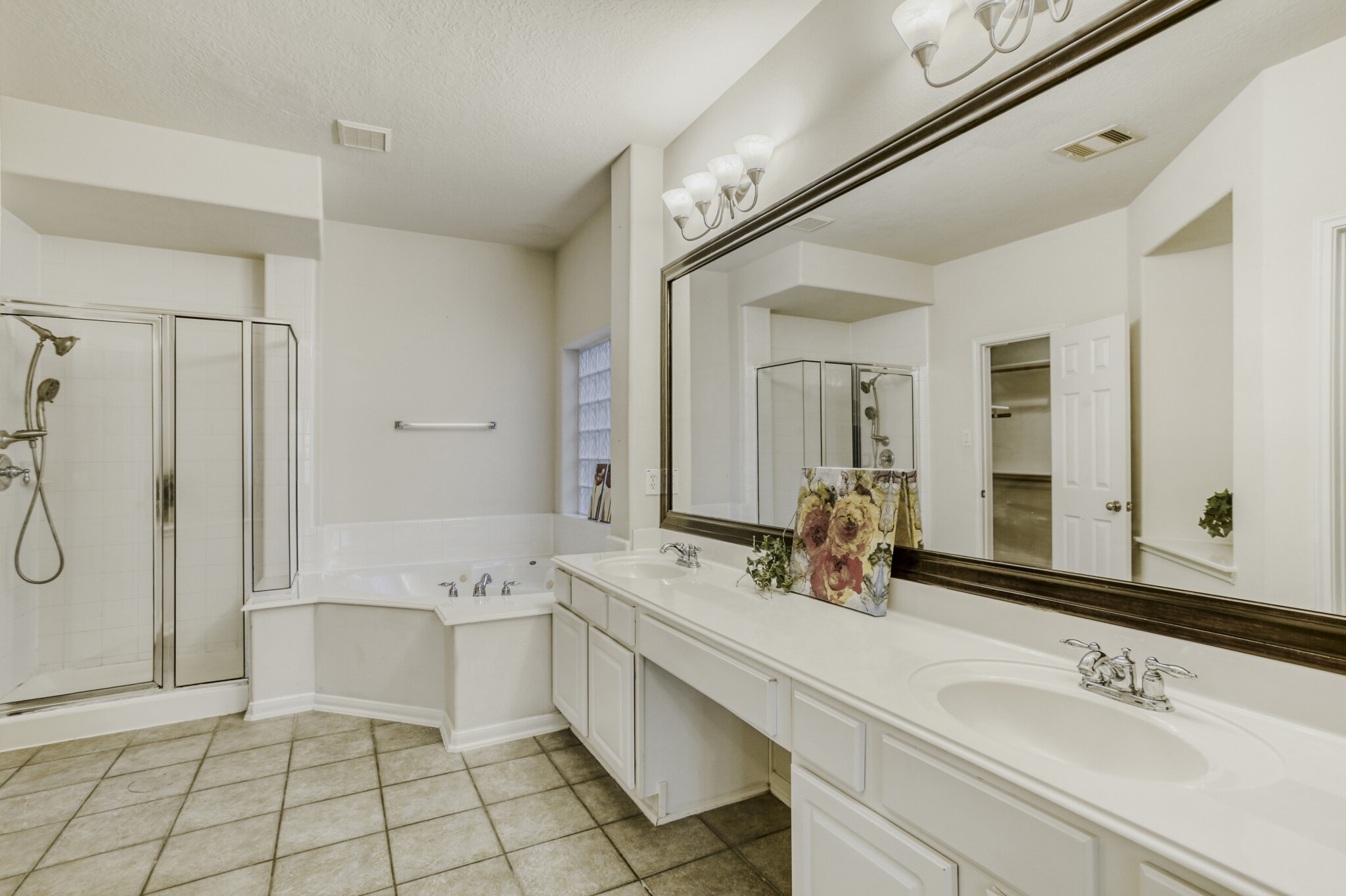 19303 Valiant Woods Drive Spring, TX 77379 - Photo 17 of 27 This elegant ensuite features a spacious layout with dual sinks, a luxurious soaking tub, and a modern glass-enclosed shower, perfect for relaxation and convenience.