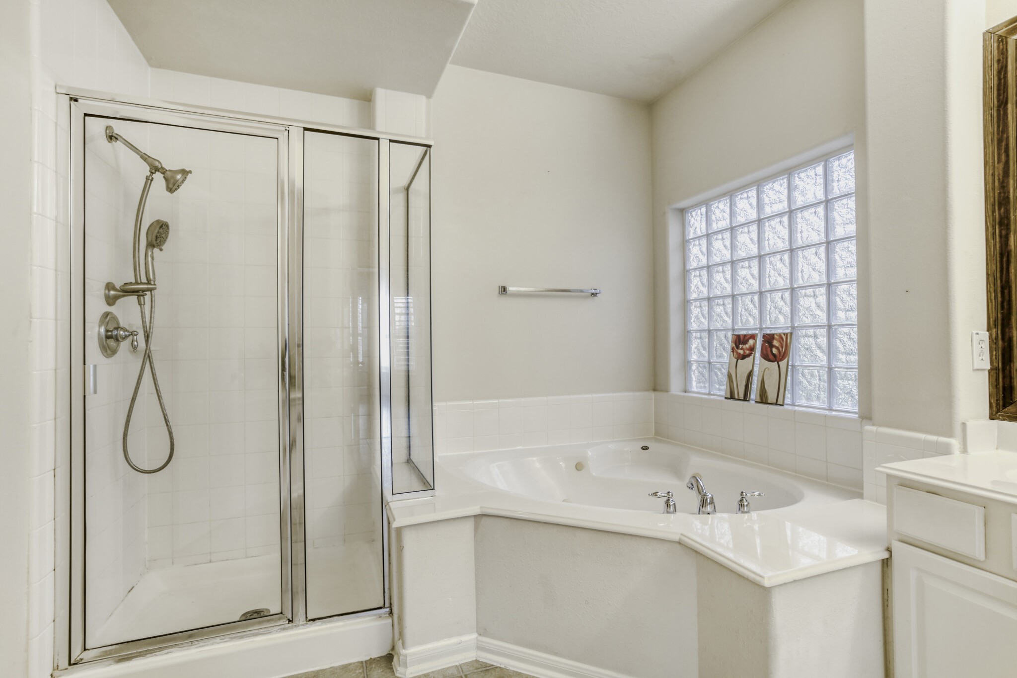 19303 Valiant Woods Drive Spring, TX 77379 - Photo 18 of 27 This inviting ensuite boasts a sleek glass-enclosed shower and a luxurious corner jacuzzi tub, perfect for unwinding in style.