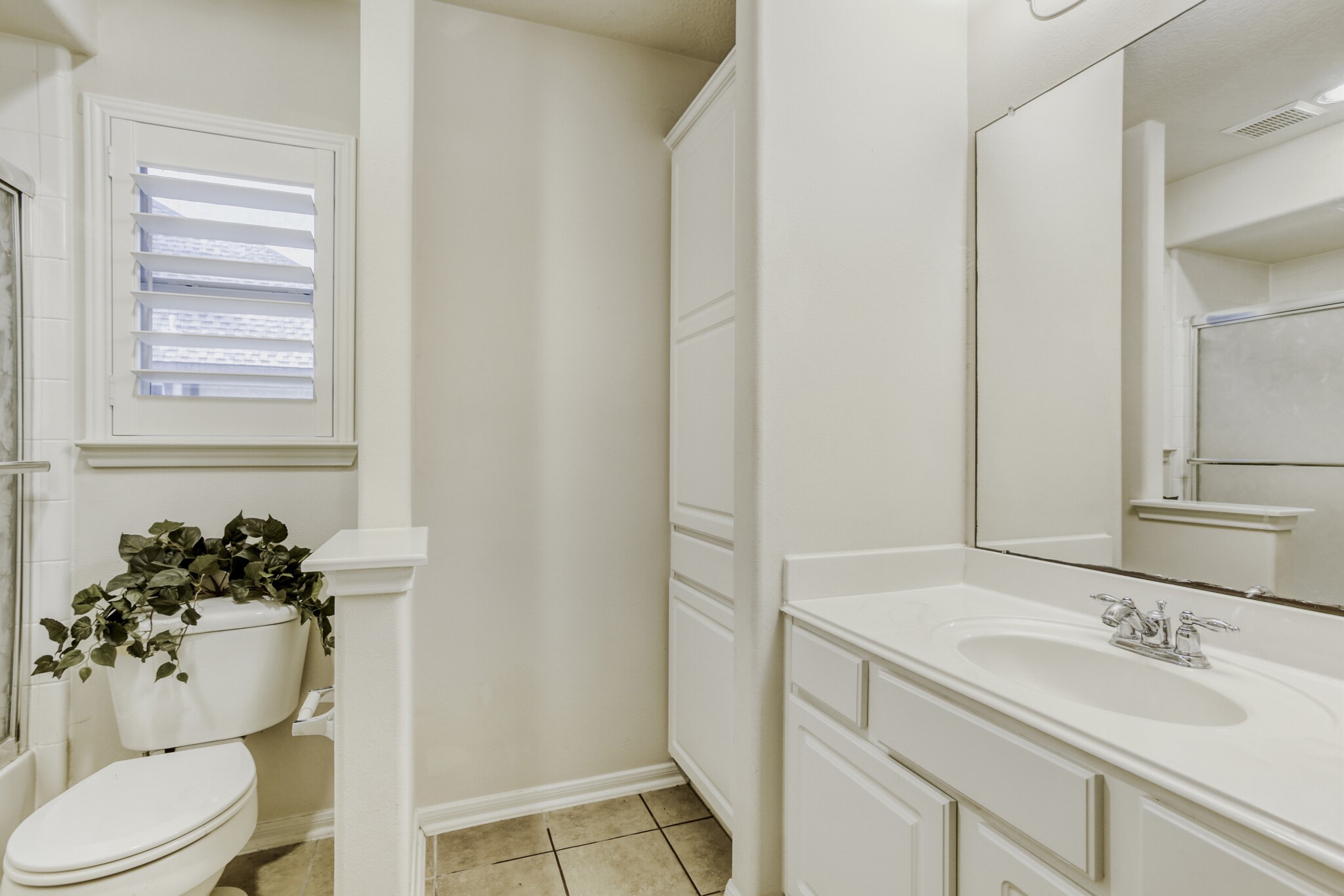 19303 Valiant Woods Drive Spring, TX 77379 - Photo 23 of 27 This bright and inviting secondary bath features elegant white cabinetry, a spacious countertop, and a sleek combination of natural light and modern fixtures, creating a refreshing retreat for family or guests.