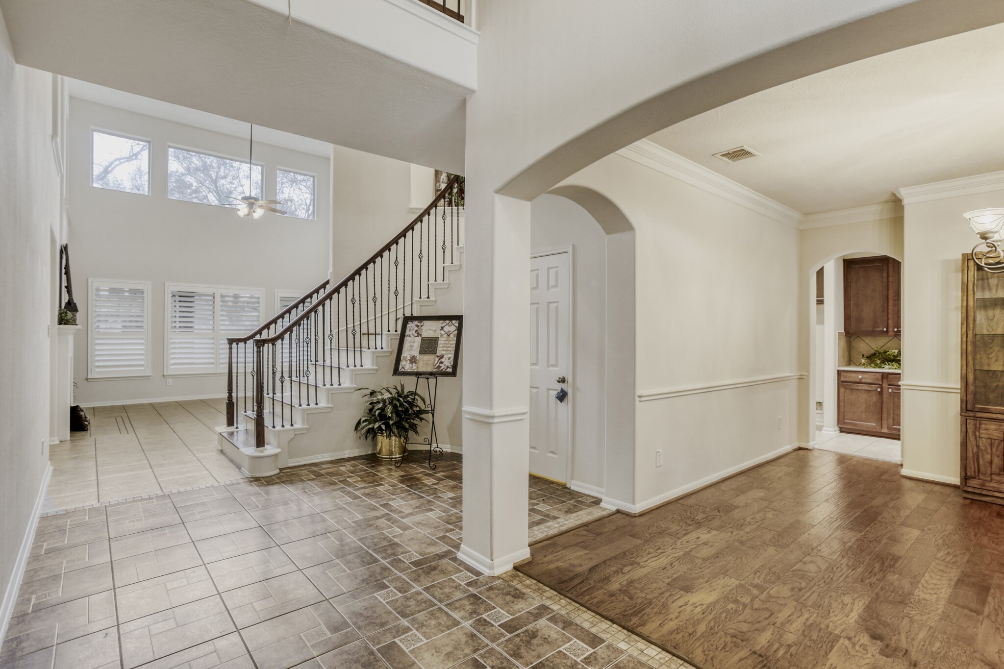 19303 Valiant Woods Drive Spring, TX 77379 - Photo 4 of 27 This inviting entrance welcomes you with elegant tile and wood flooring, a stunning staircase, and abundant natural light, setting the tone for a warm and sophisticated home.
