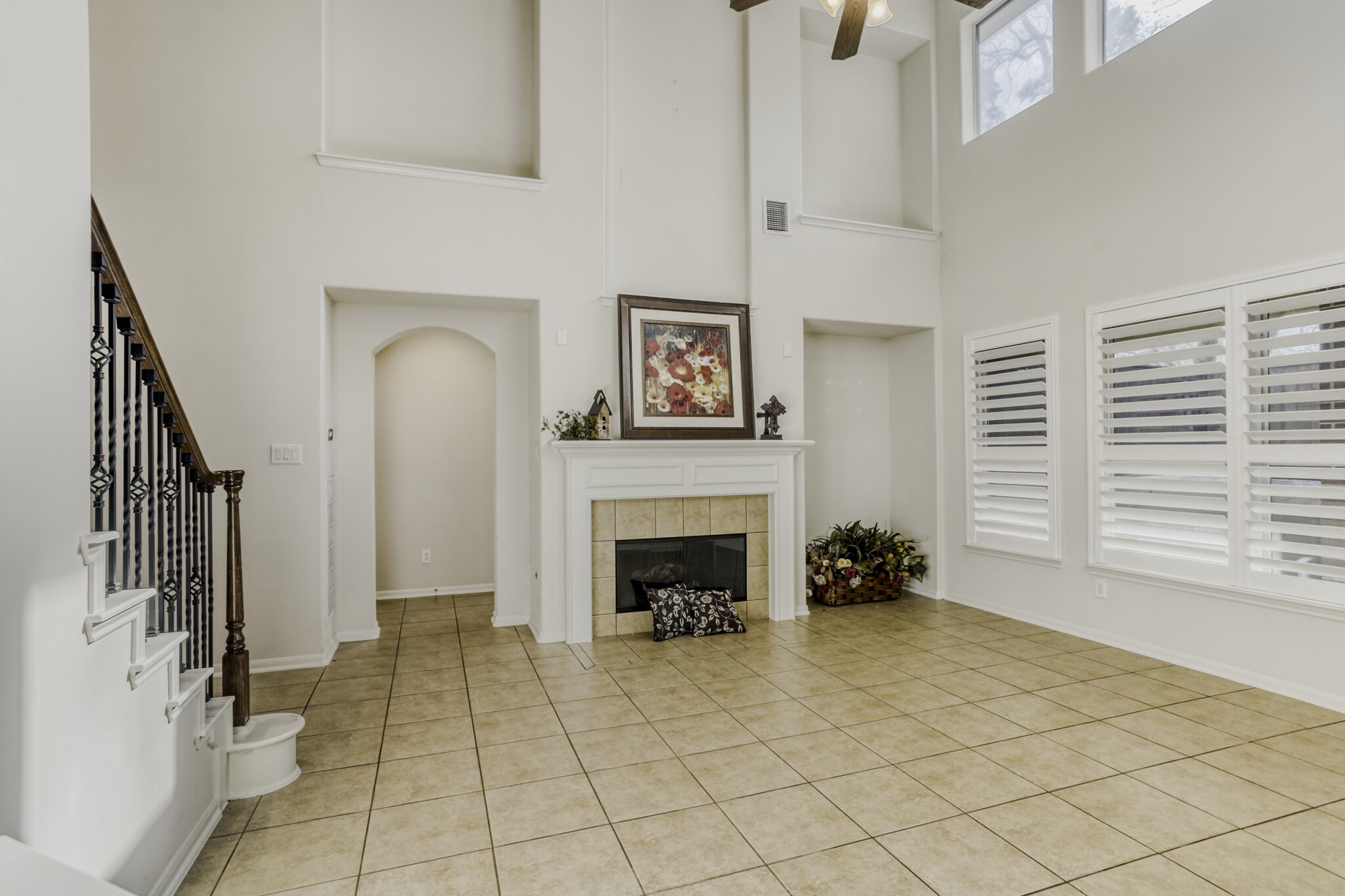 19303 Valiant Woods Drive Spring, TX 77379 - Photo 8 of 27 This expansive den features soaring ceilings, abundant natural light from large windows, a cozy fireplace, and elegant tile flooring, creating a perfect blend of comfort and style.