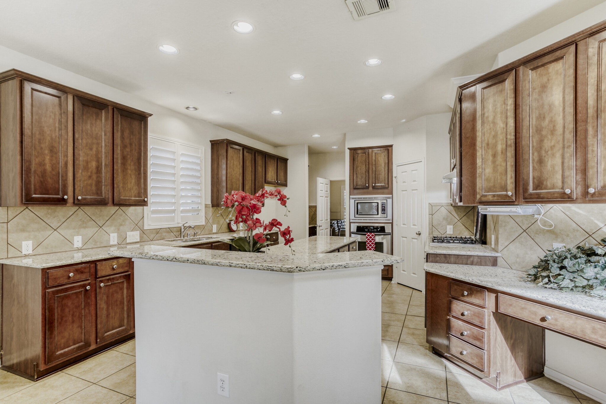 19303 Valiant Woods Drive Spring, TX 77379 - Photo 9 of 27 Discover a spacious and inviting kitchen featuring elegant granite countertops, rich wooden cabinetry, and modern appliances, perfect for culinary enthusiasts and family gatherings.