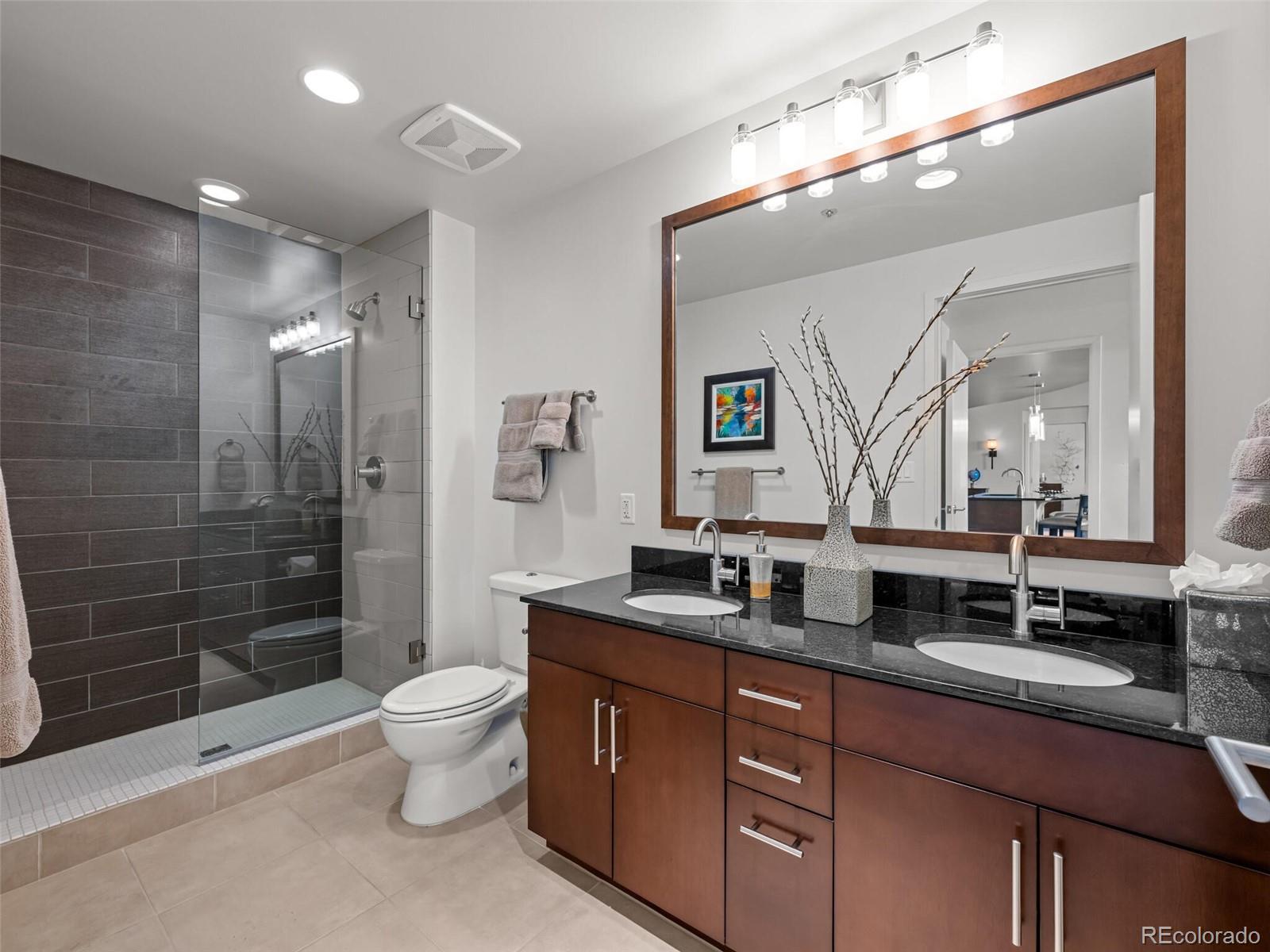 891 14th Street, Unit 3510 Denver, CO 80202 - Photo 25 of 50 a bathroom with a double vanity sink toilet and shower