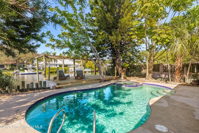 a view of yard with swimming pool and trees