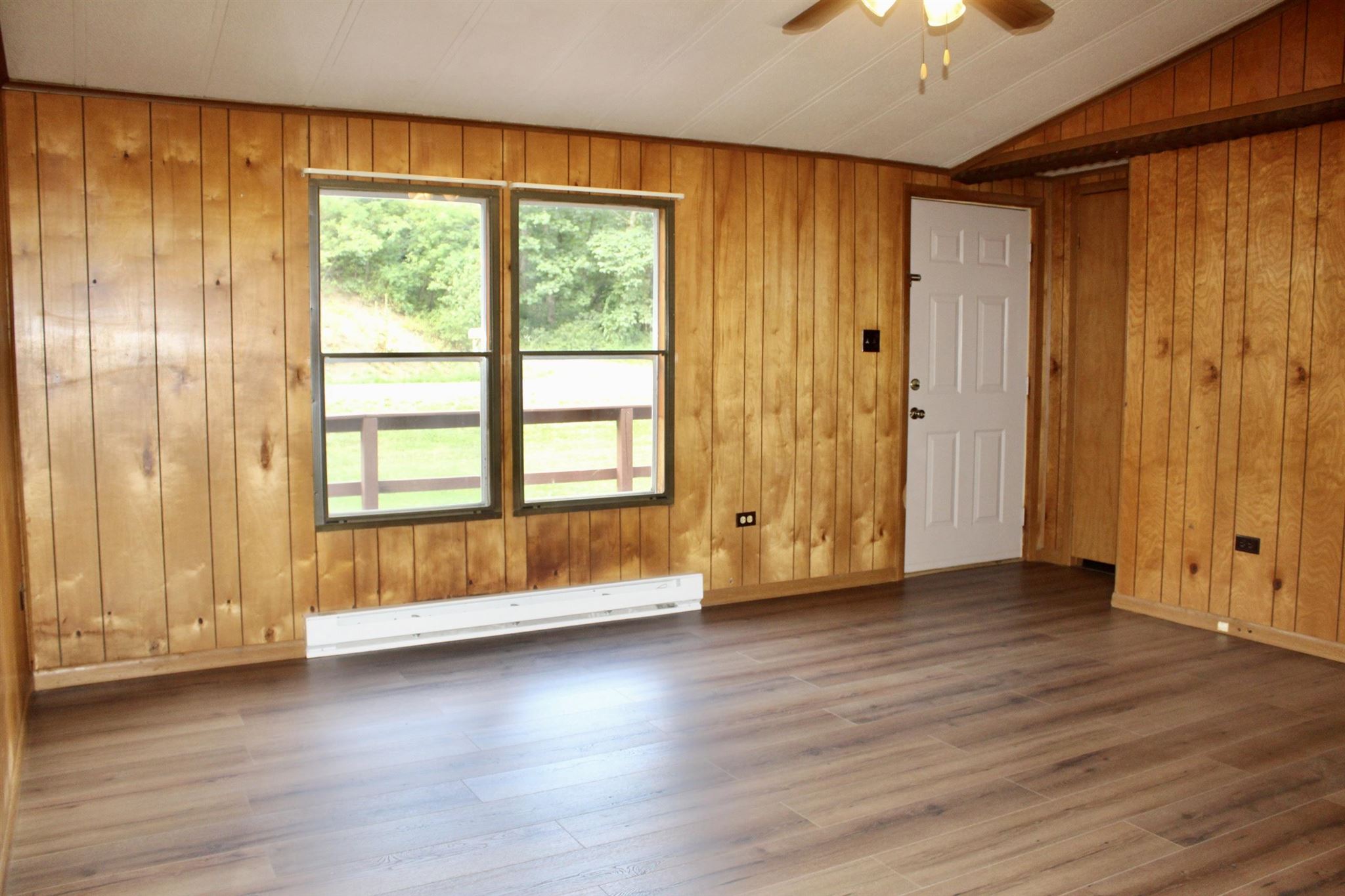 10331 Union Springs Road Dayton, VA 22821 - Photo 6 of 10 an empty room with wooden floor and windows with curtains