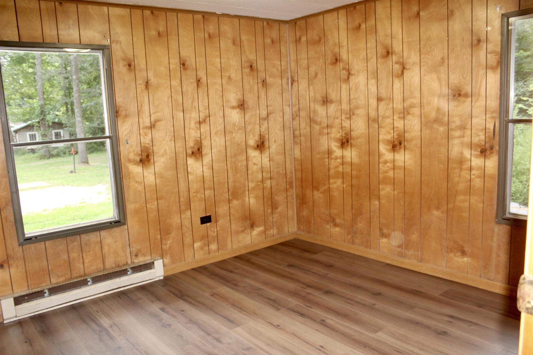 10331 Union Springs Road Dayton, VA 22821 - Photo 9 of 10 an empty room with wooden floor and windows with curtains