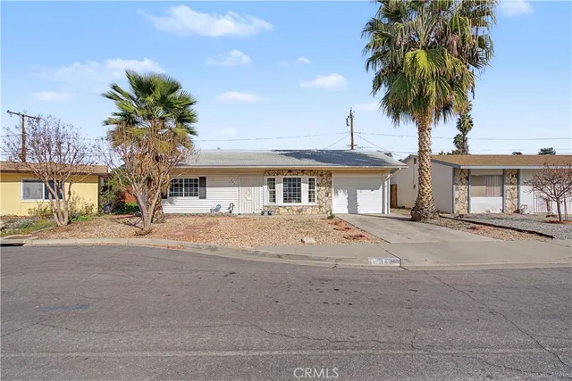 a front view of a house with garden and parking