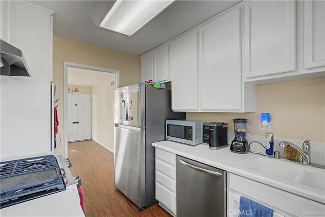 a kitchen with stainless steel appliances a refrigerator sink and cabinets