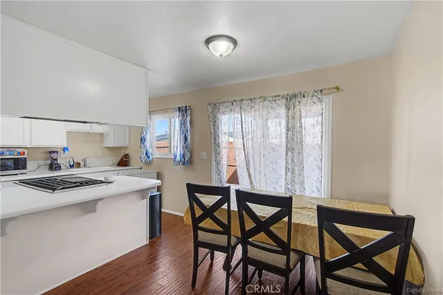 a kitchen that has a table chairs and wooden cabinets
