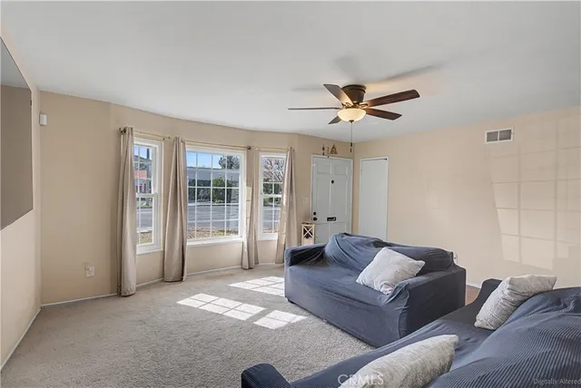 a living room with furniture and ceiling fan