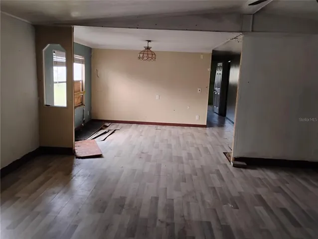 an empty room with wooden floor and entrance