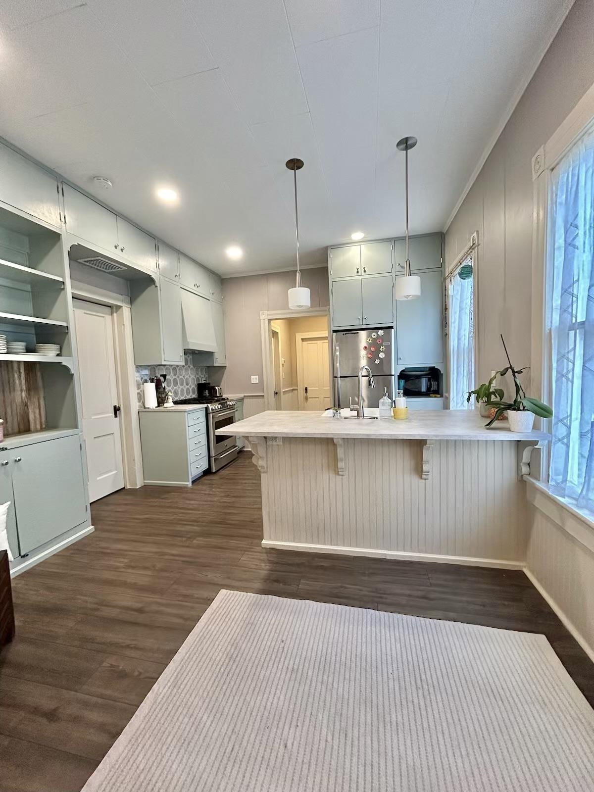 8 Rohde Avenue, Unit 1 St. Augustine, FL 32084 - Photo 2 of 11 a kitchen with stainless steel appliances kitchen island granite countertop a refrigerator a stove and a wooden floors