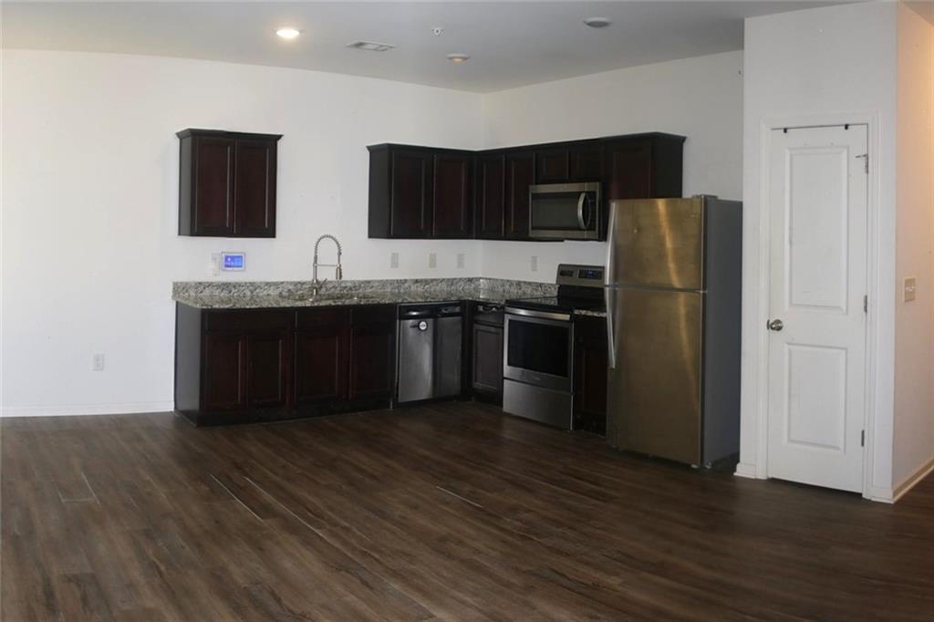 1625 Honeysuckle Path Conyers, GA 30012 - Photo 6 of 17 a kitchen with stainless steel appliances granite countertop a refrigerator and a sink
